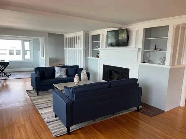 a living room with furniture a flat screen tv and a fireplace