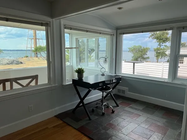 a view of a workspace with furniture and a window