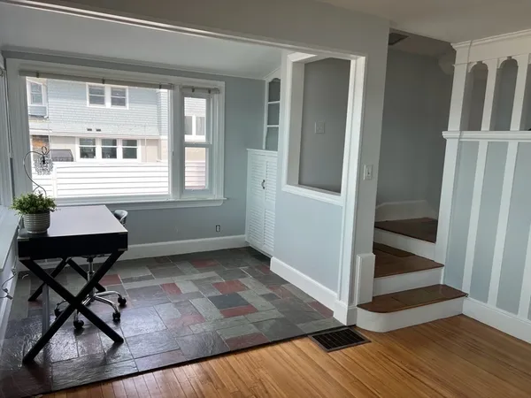 a workspace with wooden floor and a window