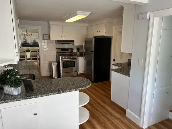 a kitchen with granite countertop a refrigerator and a sink