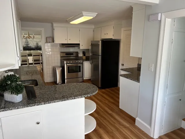 a kitchen with granite countertop a refrigerator and a sink
