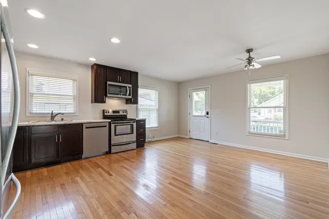 a kitchen with granite countertop a refrigerator stove top oven and sink