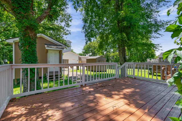 a view of a deck with a floor to ceiling window and wooden fence