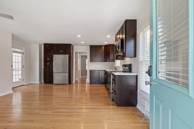 a kitchen with stainless steel appliances granite countertop a refrigerator a stove top oven a sink and dishwasher