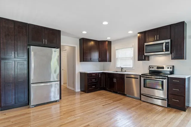 a kitchen with stainless steel appliances granite countertop a refrigerator stove and sink