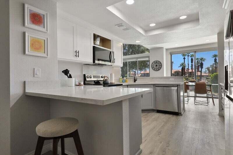 55288 Firestone La Quinta, CA 92253 - Photo 4 of 20 a kitchen with stainless steel appliances a sink a stove a refrigerator cabinets and a dining table