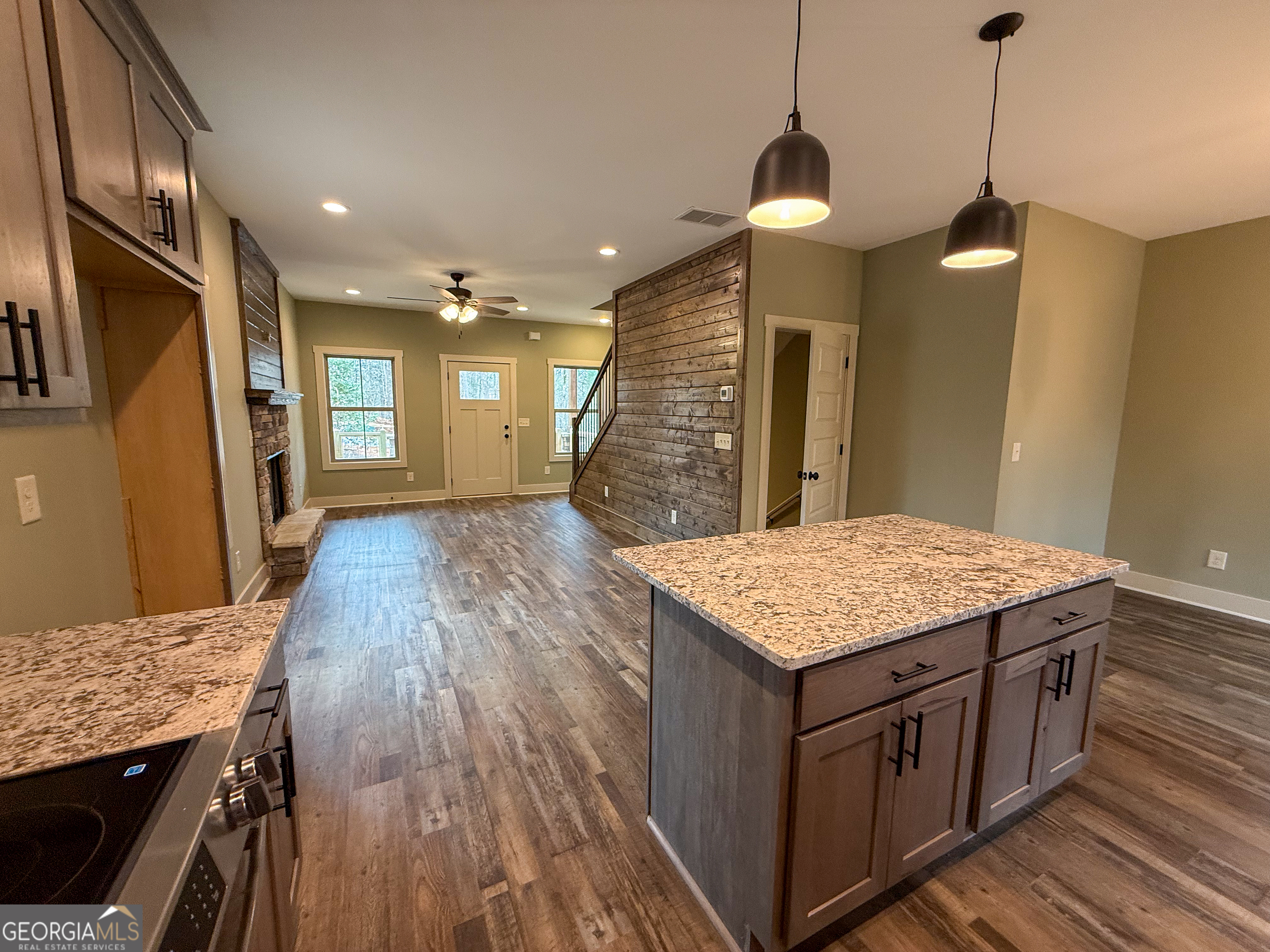 a kitchen with kitchen island wooden floor center island and stainless steel appliances