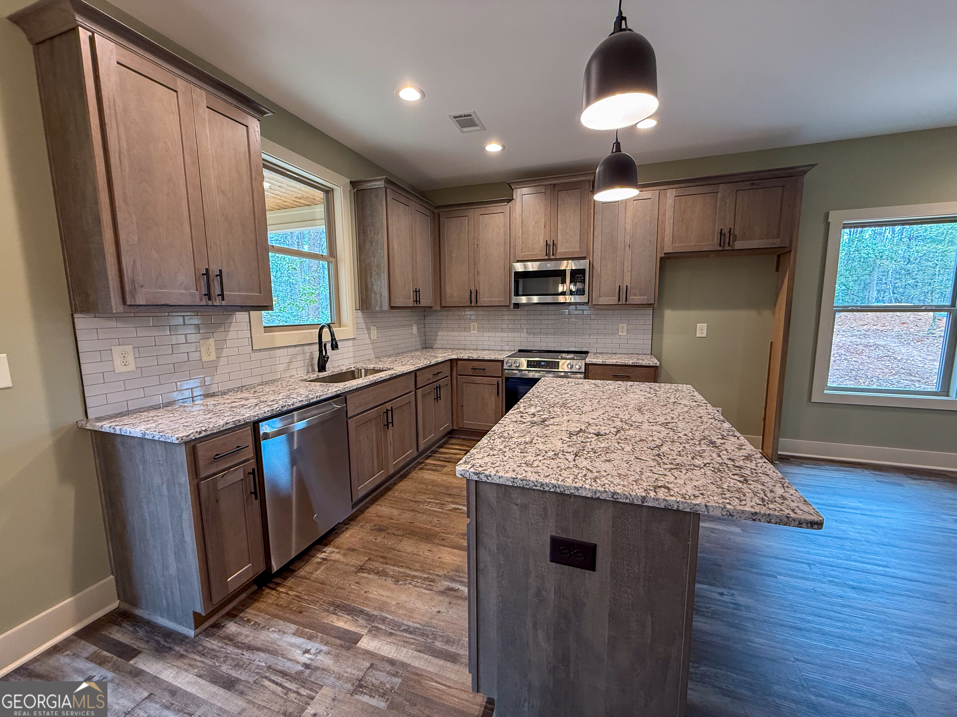 18 Creek Bend Point Cleveland, GA 30528 - Photo 3 of 37 a kitchen with kitchen island granite countertop wooden cabinets a sink a stove a refrigerator and island