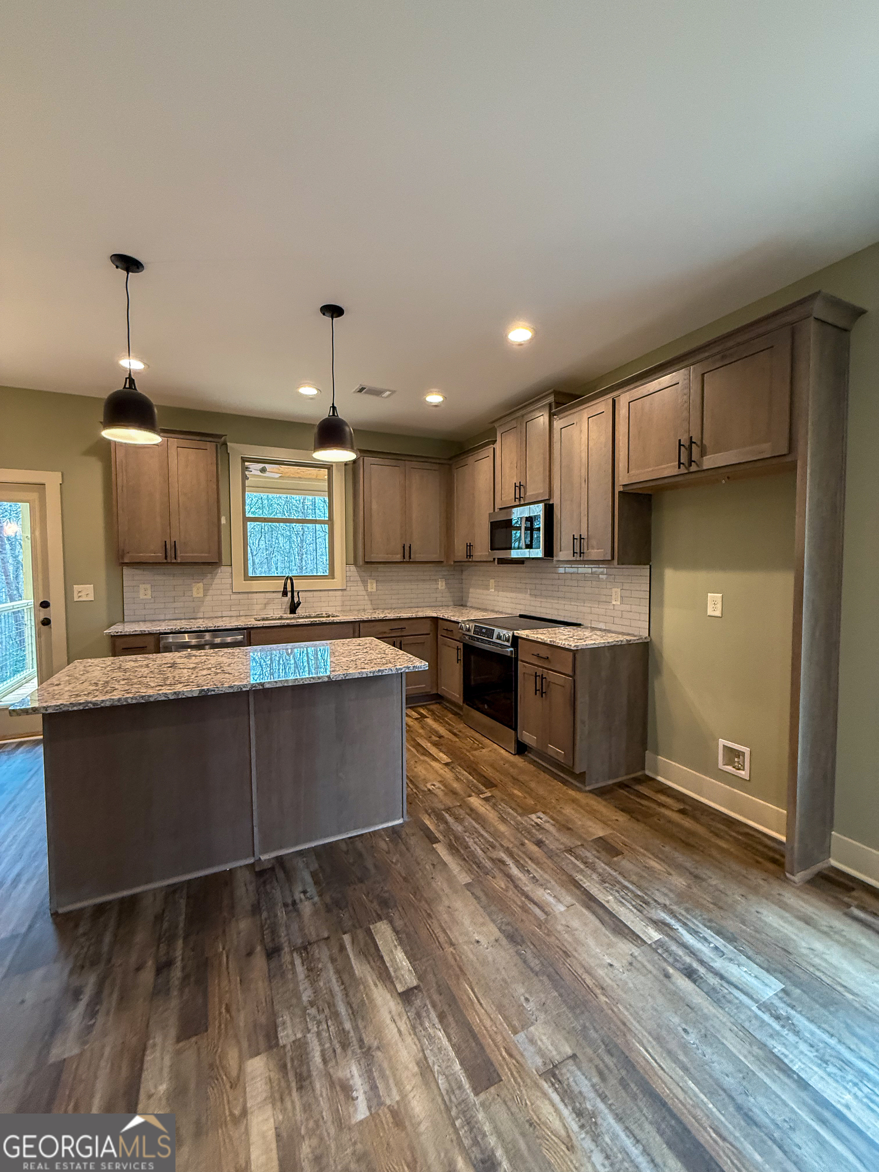 18 Creek Bend Point Cleveland, GA 30528 - Photo 5 of 37 a large kitchen with stainless steel appliances kitchen island granite countertop a stove a sink dishwasher and a refrigerator