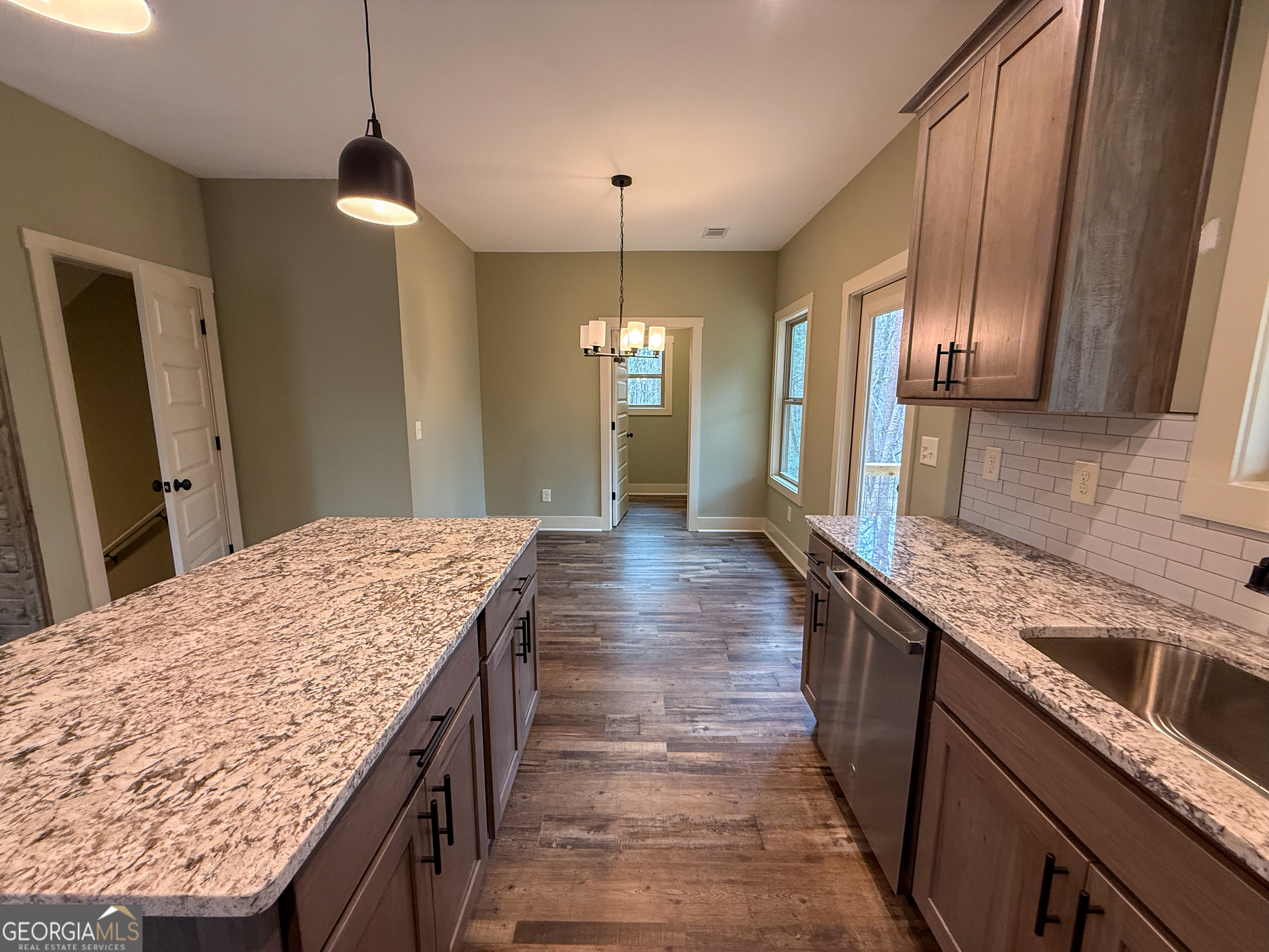 18 Creek Bend Point Cleveland, GA 30528 - Photo 6 of 37 a kitchen with kitchen island granite countertop a sink and wooden cabinets