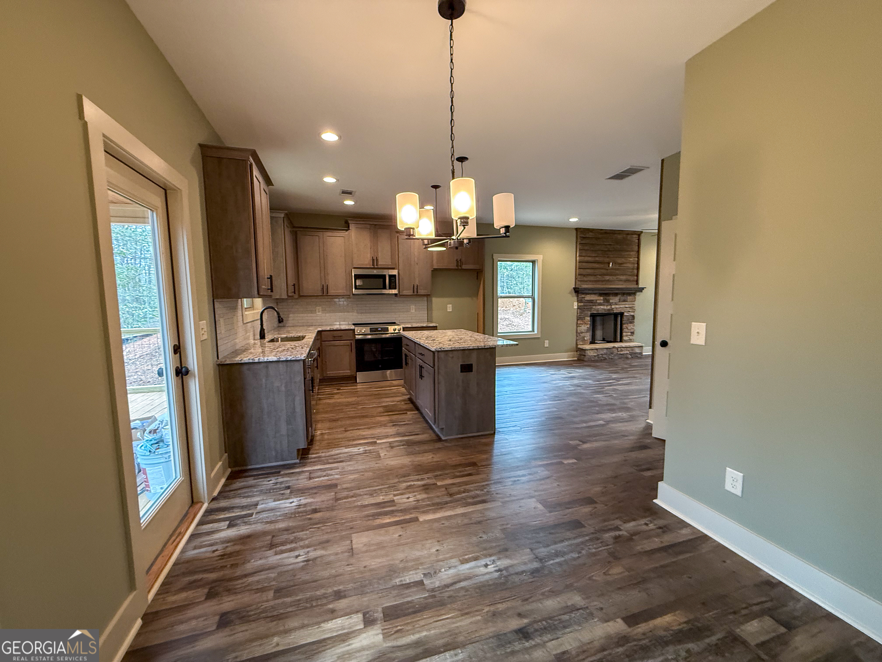 18 Creek Bend Point Cleveland, GA 30528 - Photo 7 of 37 a kitchen with stainless steel appliances granite countertop a refrigerator a sink dishwasher a stove and a dining table with wooden floor