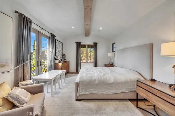 a spacious bedroom with a large bed and a chandelier