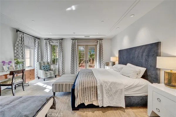 a bedroom with a bed and large windows