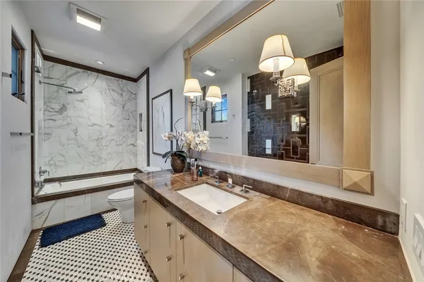 a bathroom with a granite countertop sink mirror and a bathtub