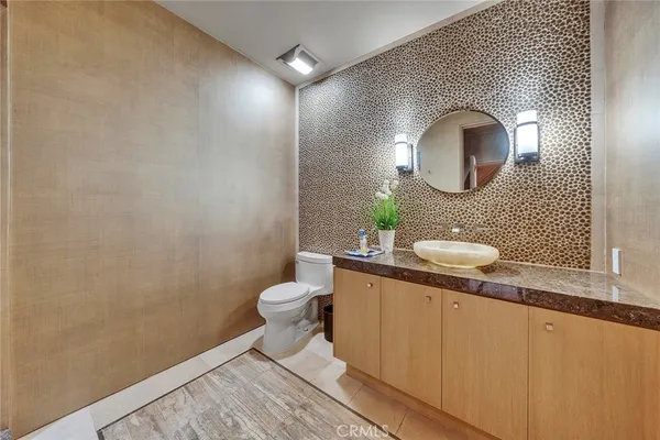 a bathroom with a toilet a sink and mirror