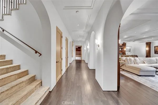 a view of a hallway with wooden floor and furniture