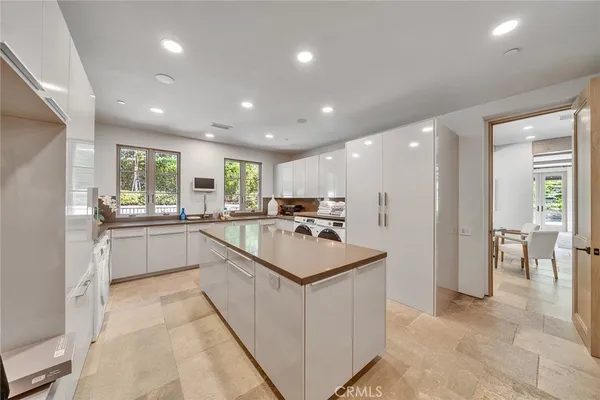 a large white kitchen with a sink and white stainless steel appliances