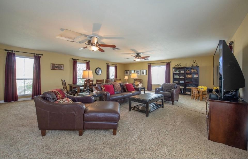 1230 Minarets Avenue Clovis, CA 93611 - Photo 6 of 19 a living room with furniture a chandelier fan and a window