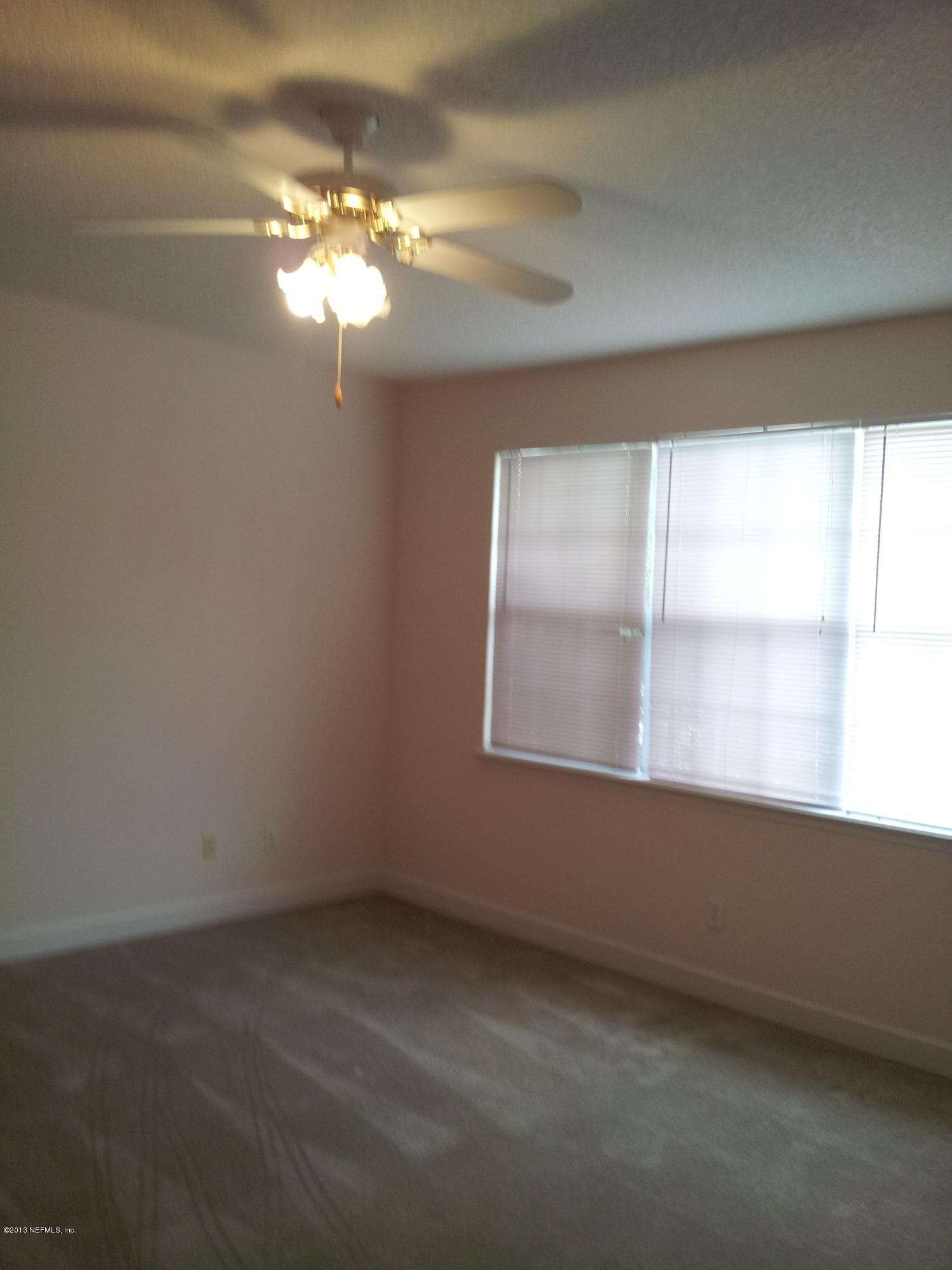 3162 Ravines Road Middleburg, FL 32068 - Photo 9 of 16 wooden floor in an empty room with a window