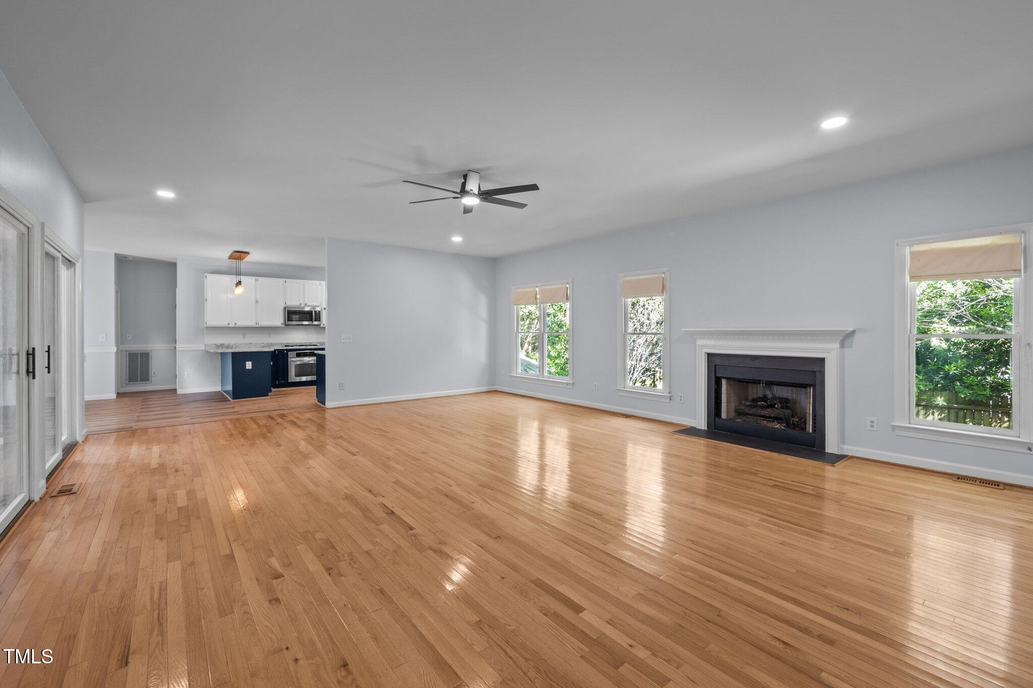 2123 Fountain Ridge Road Chapel Hill, NC 27707 - Photo 5 of 46 an empty room with a fireplace and wooden floor
