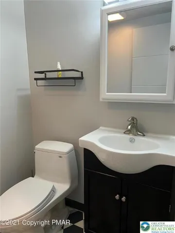 a bathroom with a sink toilet and mirror
