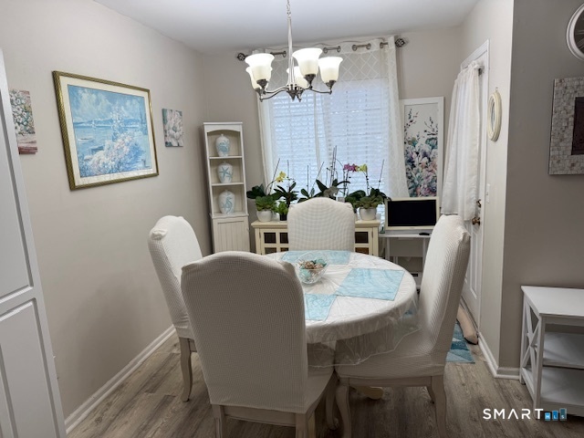 4 Arlington Court, Unit 4 Brookfield, CT 06804 - Photo 8 of 21 a view of a dining room with furniture a chandelier and wooden floor