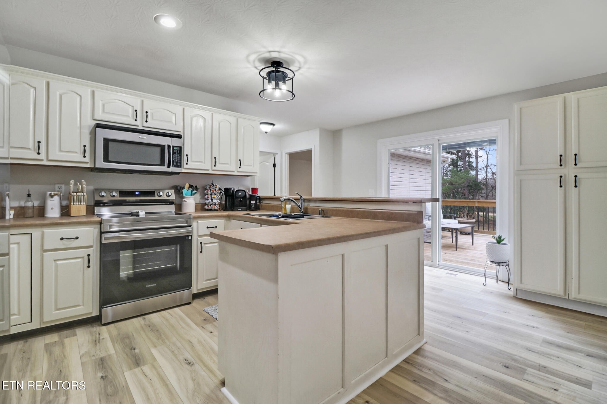 93 Tower Way Allardt, TN 38504 - Photo 20 of 40 a kitchen with stainless steel appliances granite countertop a stove top oven a sink dishwasher and a refrigerator with wooden floor