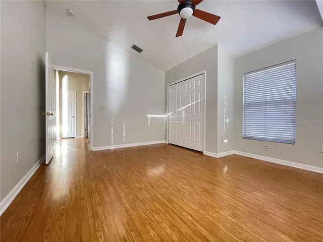 a view of a livingroom with wooden floor and a ceiling fan