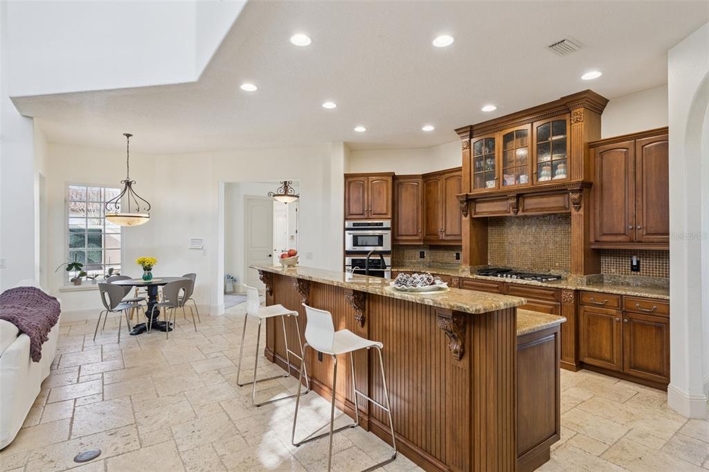 103 Acadia Terrace Celebration, FL 34747 - Photo 19 of 87 a kitchen with stainless steel appliances granite countertop a stove top oven a sink dishwasher a dining table and chairs with wooden floor