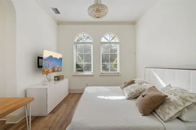 a bedroom with a bed and a chandelier