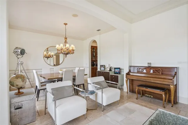 a living room with furniture chandelier and a large window