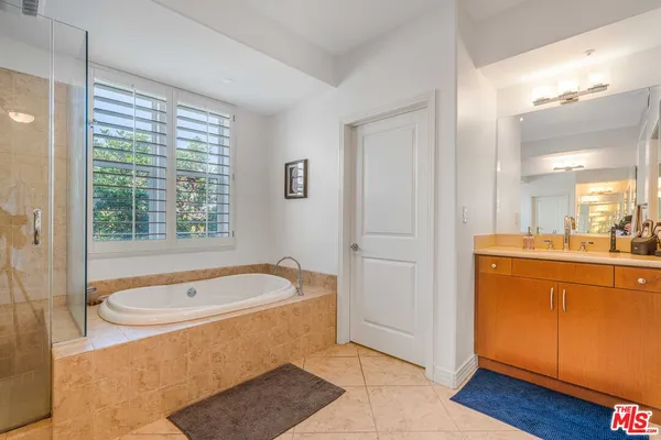 a bathroom with a tub a sink and a window