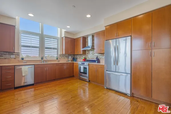 a kitchen with granite countertop stainless steel appliances a refrigerator and a sink