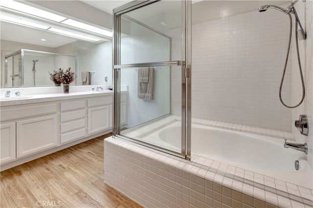 a bathroom with a tub sink and mirror