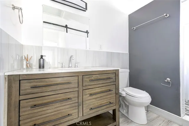 a bathroom with a toilet a sink and a mirror