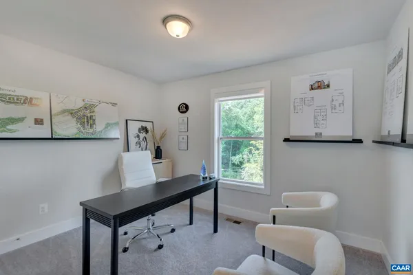 a view of a workspace with furniture and a window