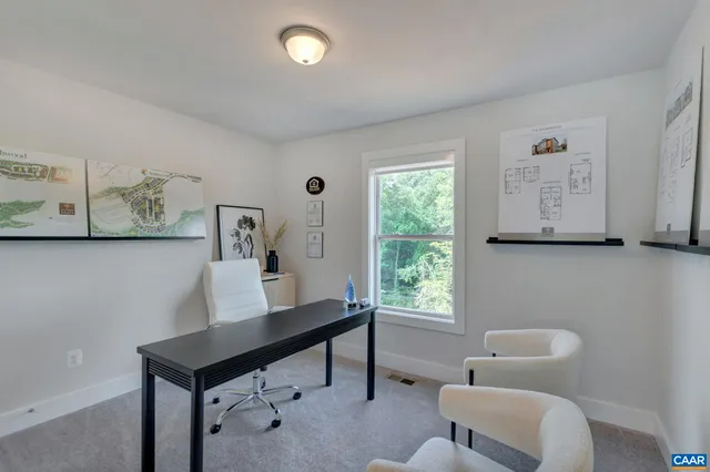 a view of a workspace with furniture and a window
