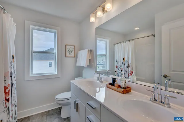 a bathroom with a sink a toilet and mirror