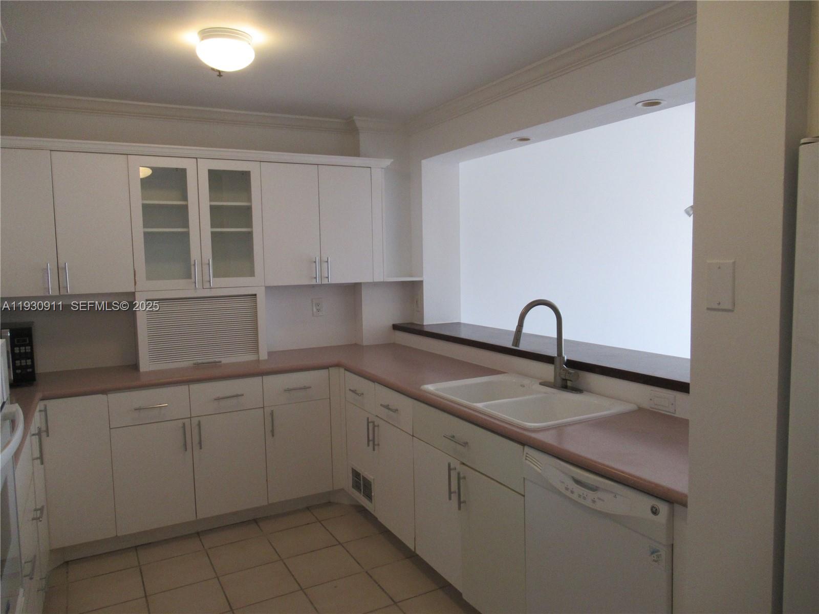 201 Crandon Boulevard, Unit 341 Key Biscayne, FL 33149 - Photo 7 of 25 a kitchen with a sink and cabinets
