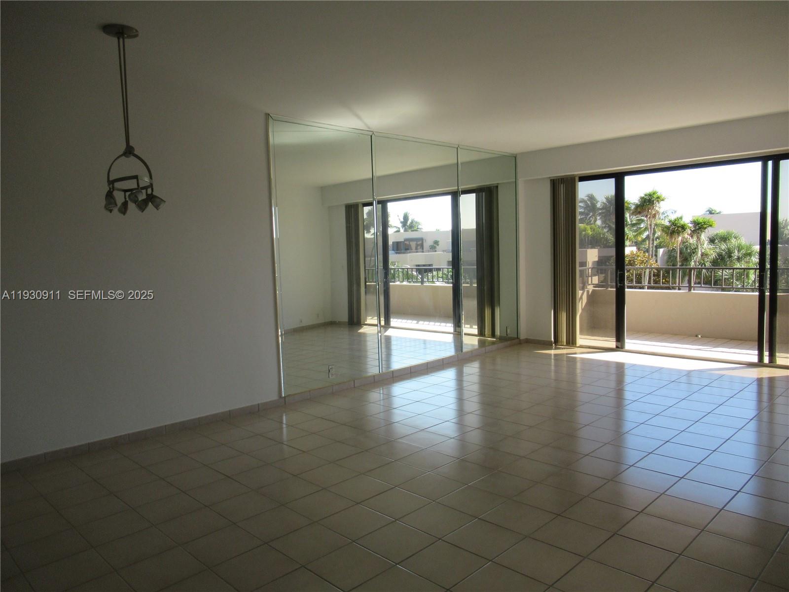 201 Crandon Boulevard, Unit 341 Key Biscayne, FL 33149 - Photo 8 of 25 a view of empty room with wooden floor and fan