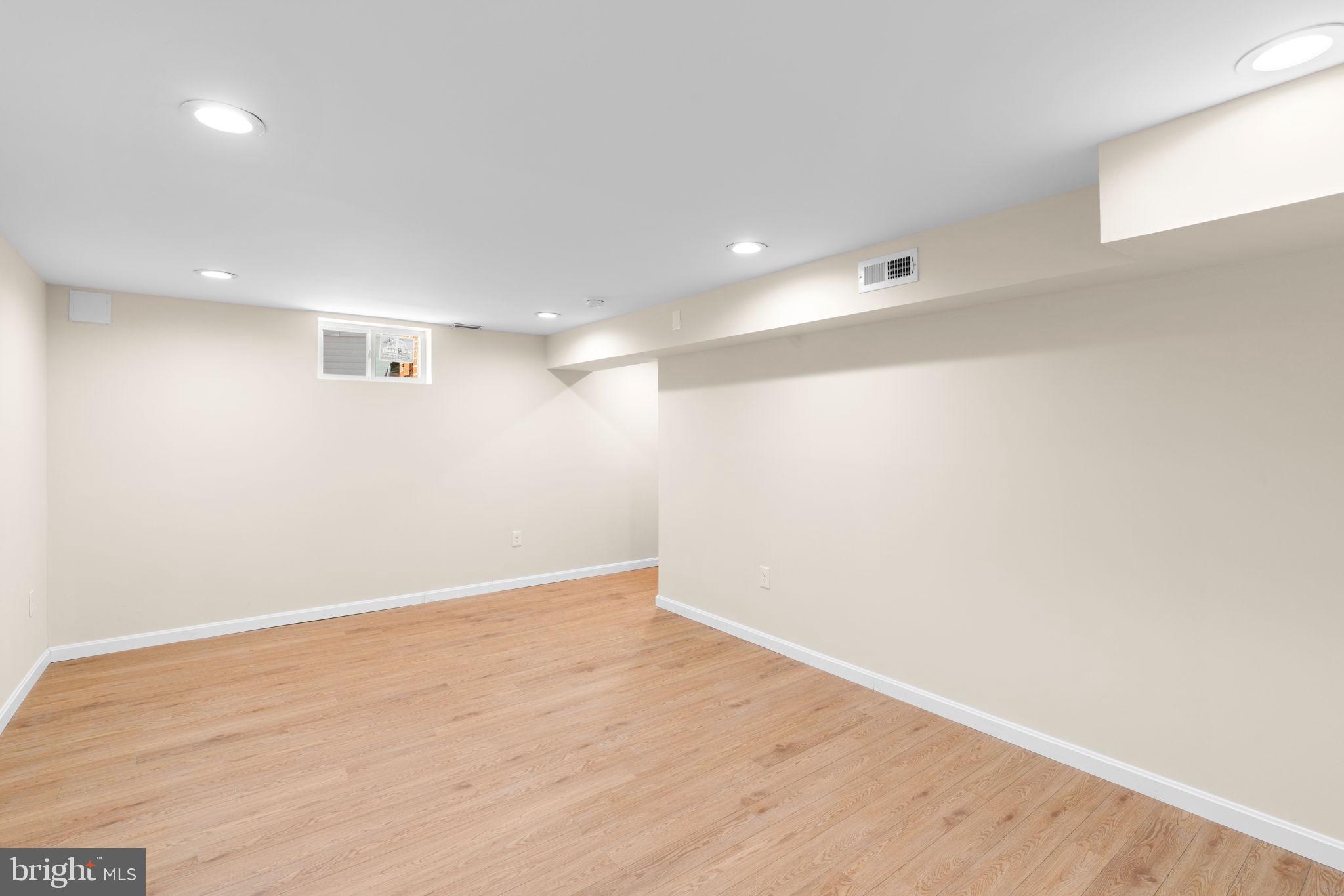 7134 Bexhill Road Windsor Mill, MD 21244 - Photo 27 of 34 an empty room with wooden floor and white walls