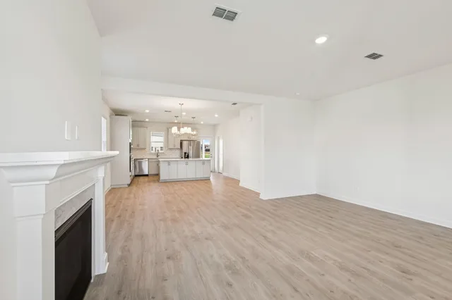 a large kitchen with granite countertop a large kitchen island sink refrigerator and cabinets