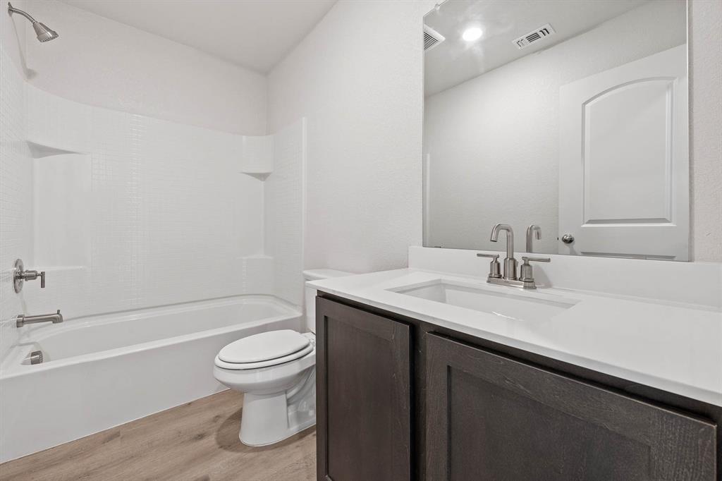 9964 Voyager Lane Fort Worth, TX 76131 - Photo 10 of 10 a bathroom with a granite countertop sink a toilet and a bathtub