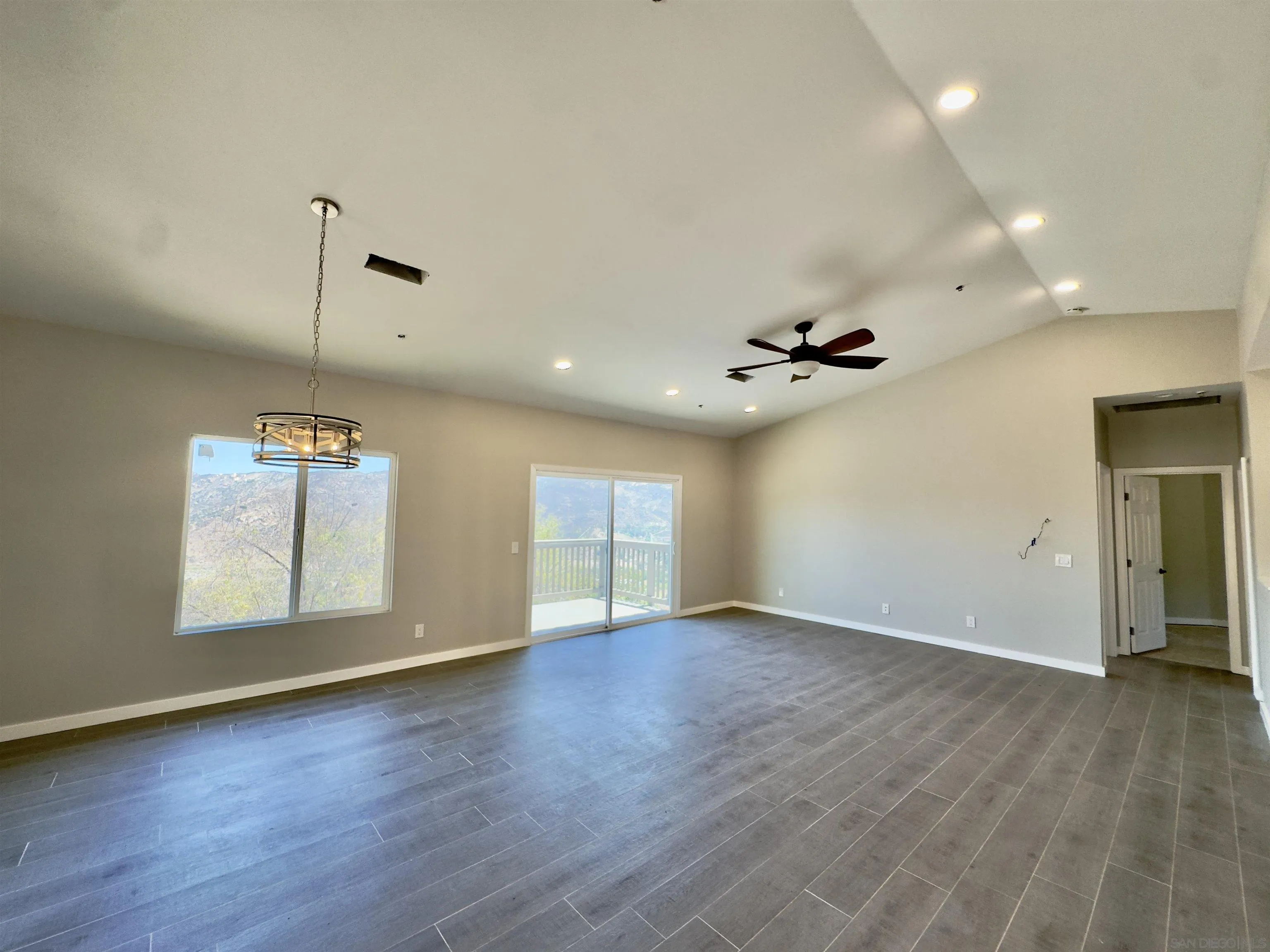 11677 Valle Vista Road Lakeside, CA 92040 - Photo 13 of 44 an empty room with wooden floor chandelier and windows