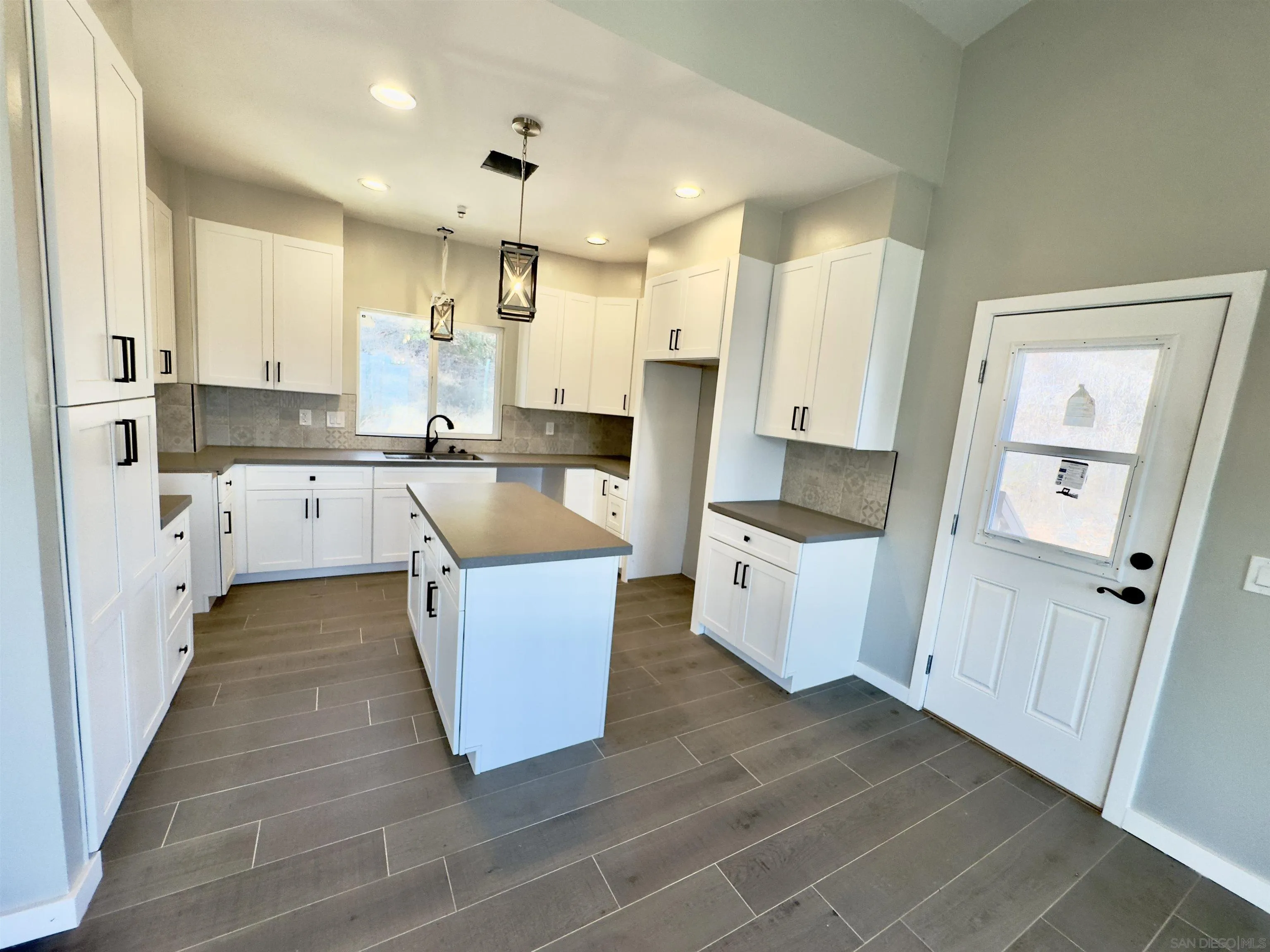11677 Valle Vista Road Lakeside, CA 92040 - Photo 17 of 44 a large kitchen with kitchen island a white counter top space and cabinets