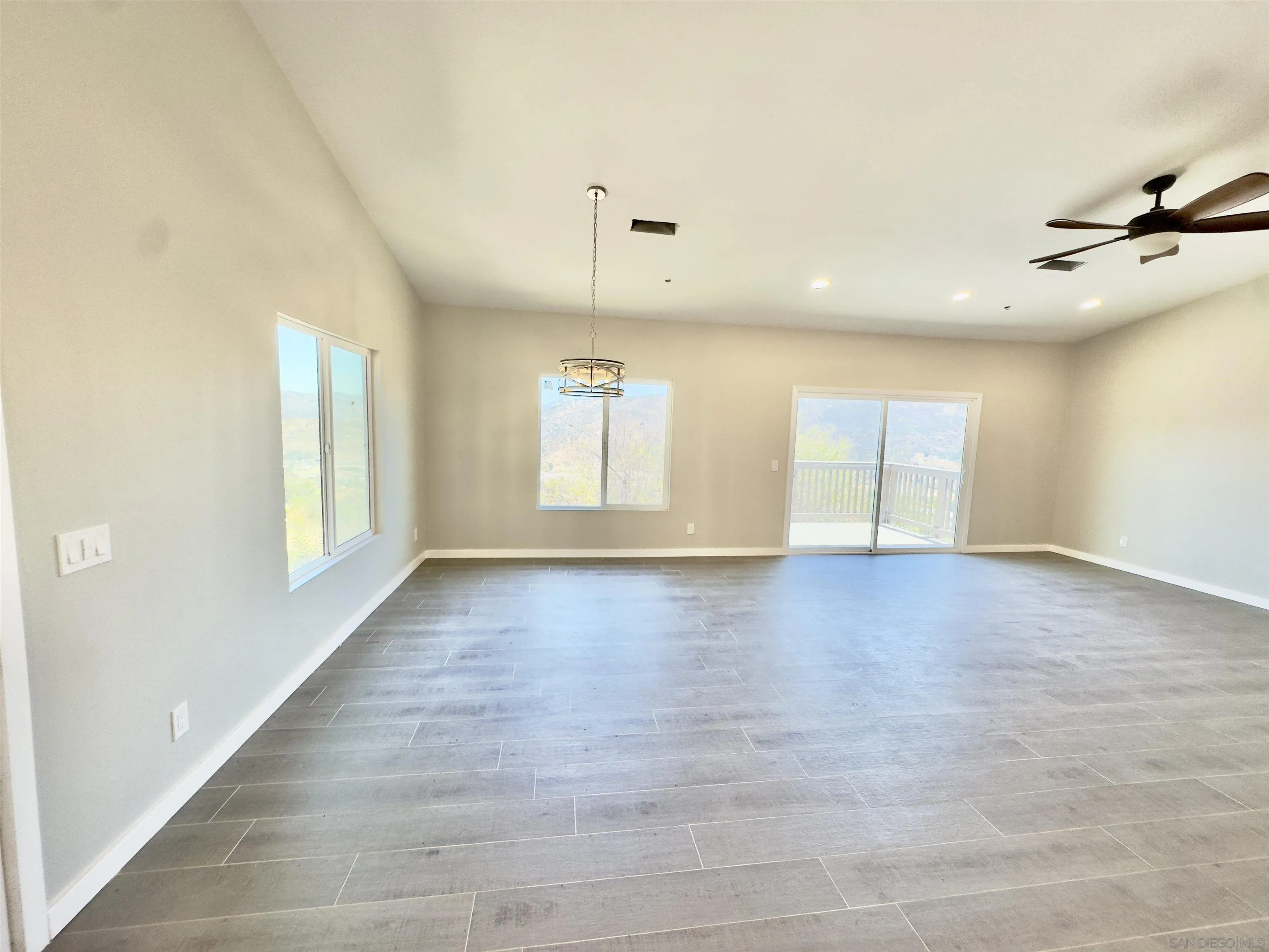 11677 Valle Vista Road Lakeside, CA 92040 - Photo 19 of 44 an empty room with wooden floor and windows