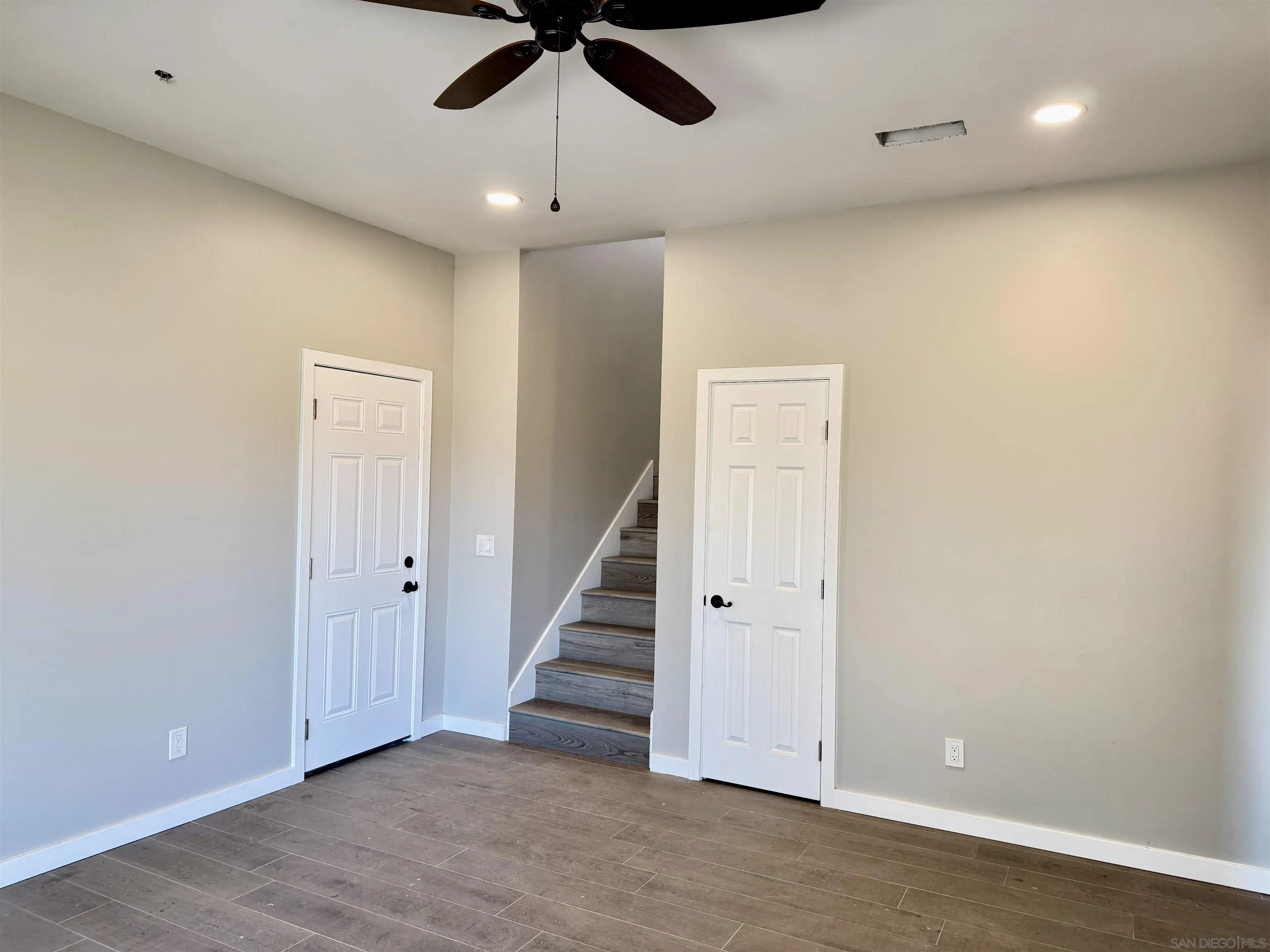 11677 Valle Vista Road Lakeside, CA 92040 - Photo 33 of 44 an empty room with wooden floor ceiling fan and entryway