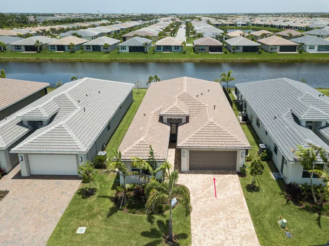 an aerial view of a house with a garden and lake view