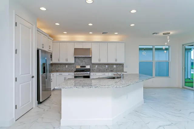 a large kitchen with stainless steel appliances lots of counter top space cabinets and a sink