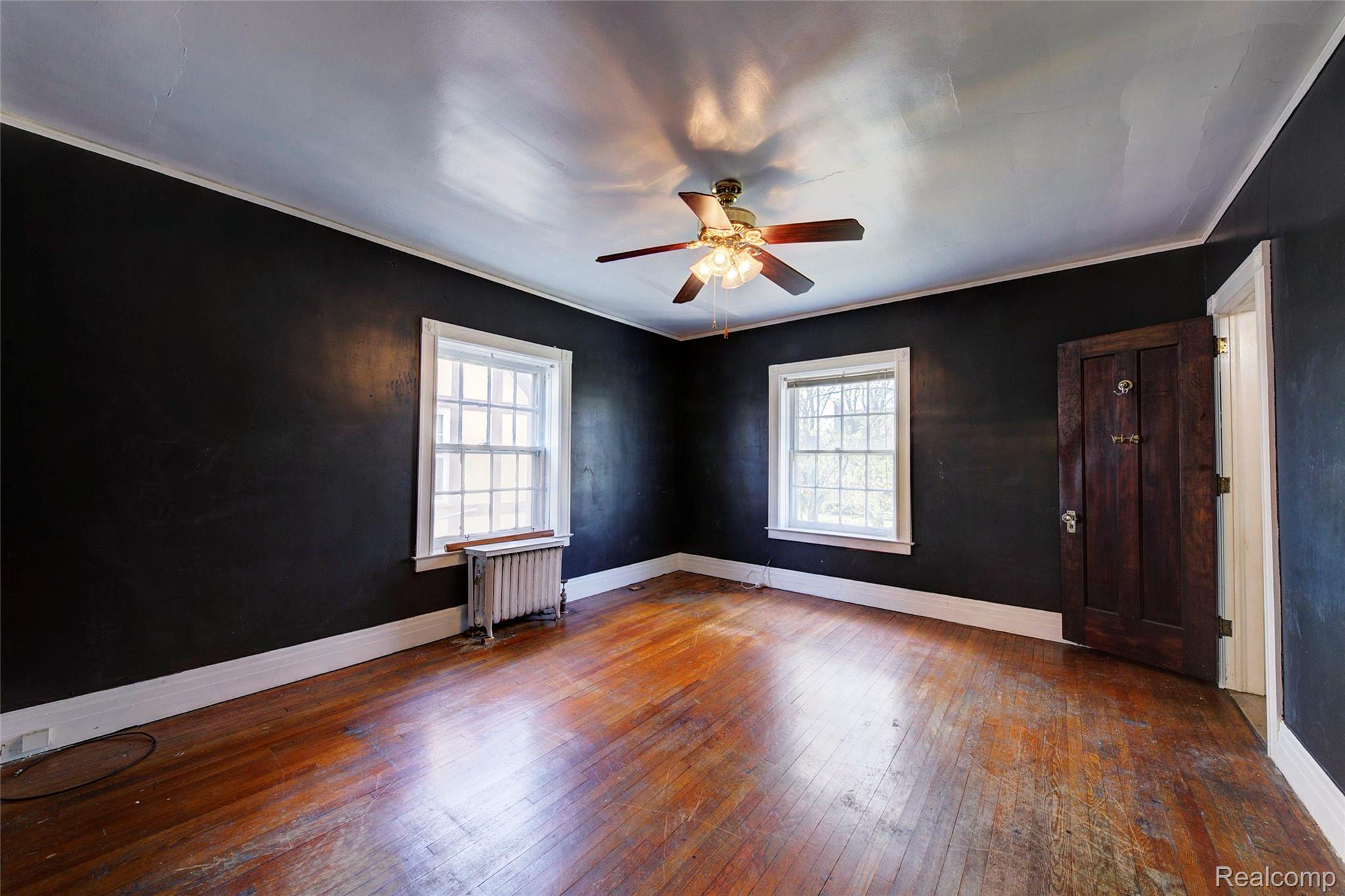 121 Longfellow Street Detroit, MI 48202 - Photo 45 of 87 Spare room with dark wood-type flooring, a ceiling fan, plenty of natural light, radiator, and ornamental molding